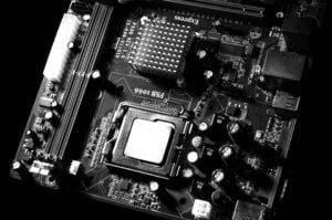 Monochrome detailed close-up of computer motherboard circuitry showcasing components and tech intricacies.
