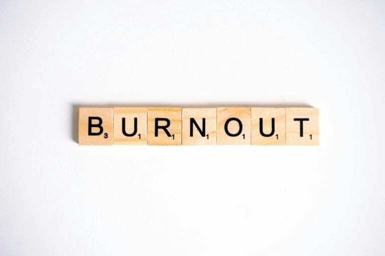 Conceptual image of 'Burnout' spelled with Scrabble tiles on a white background.